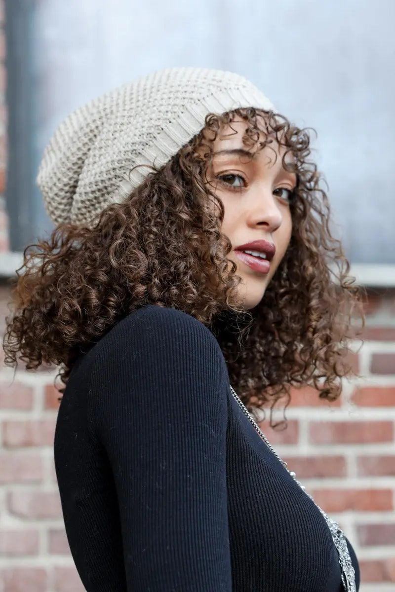 Oatmeal slouch waffle knit beanie from side, ribbed cuff and textured weave