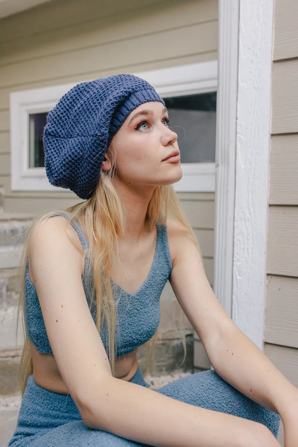 Blue slouch waffle knit beanie on head, textured waffle pattern and cuff