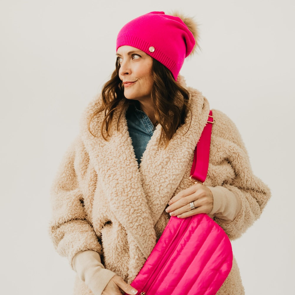 Fuchsia knit beanie with slouchy crown, ribbed cuff, and fur pom