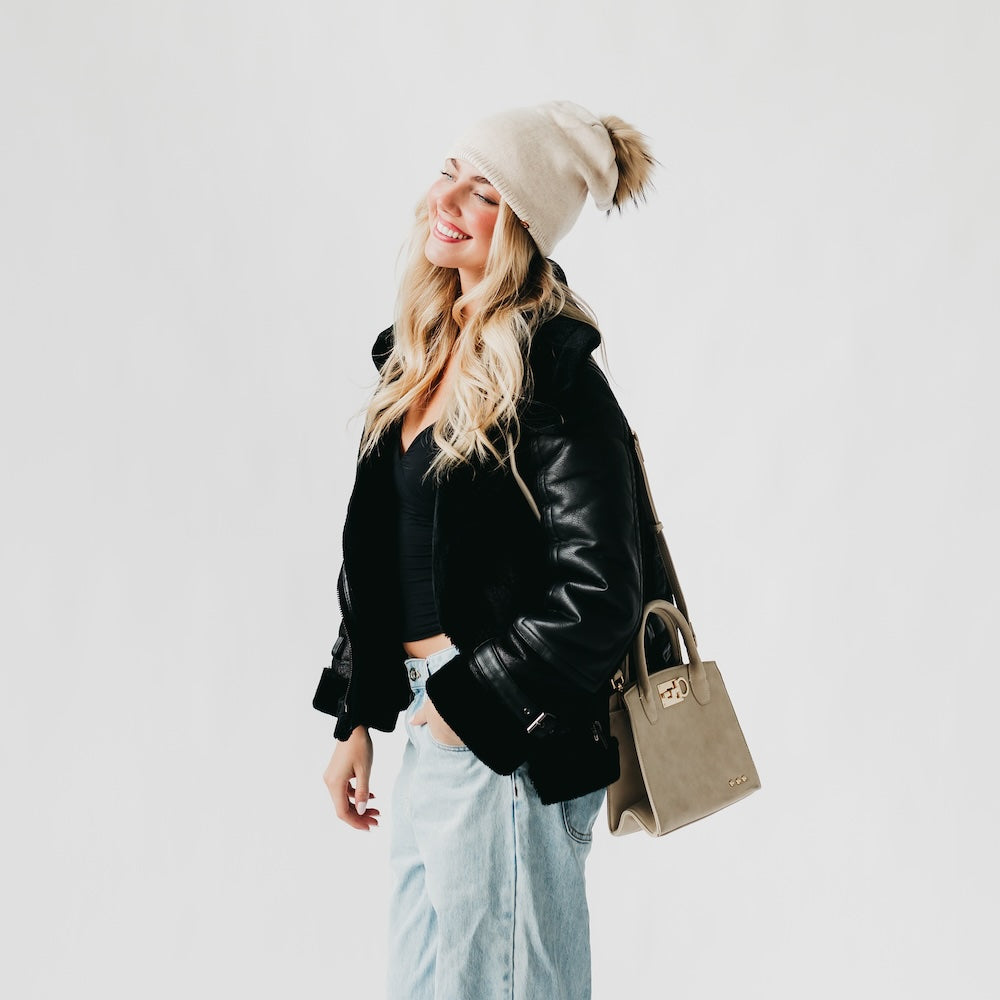 Cream knit slouchy beanie with a fur pom