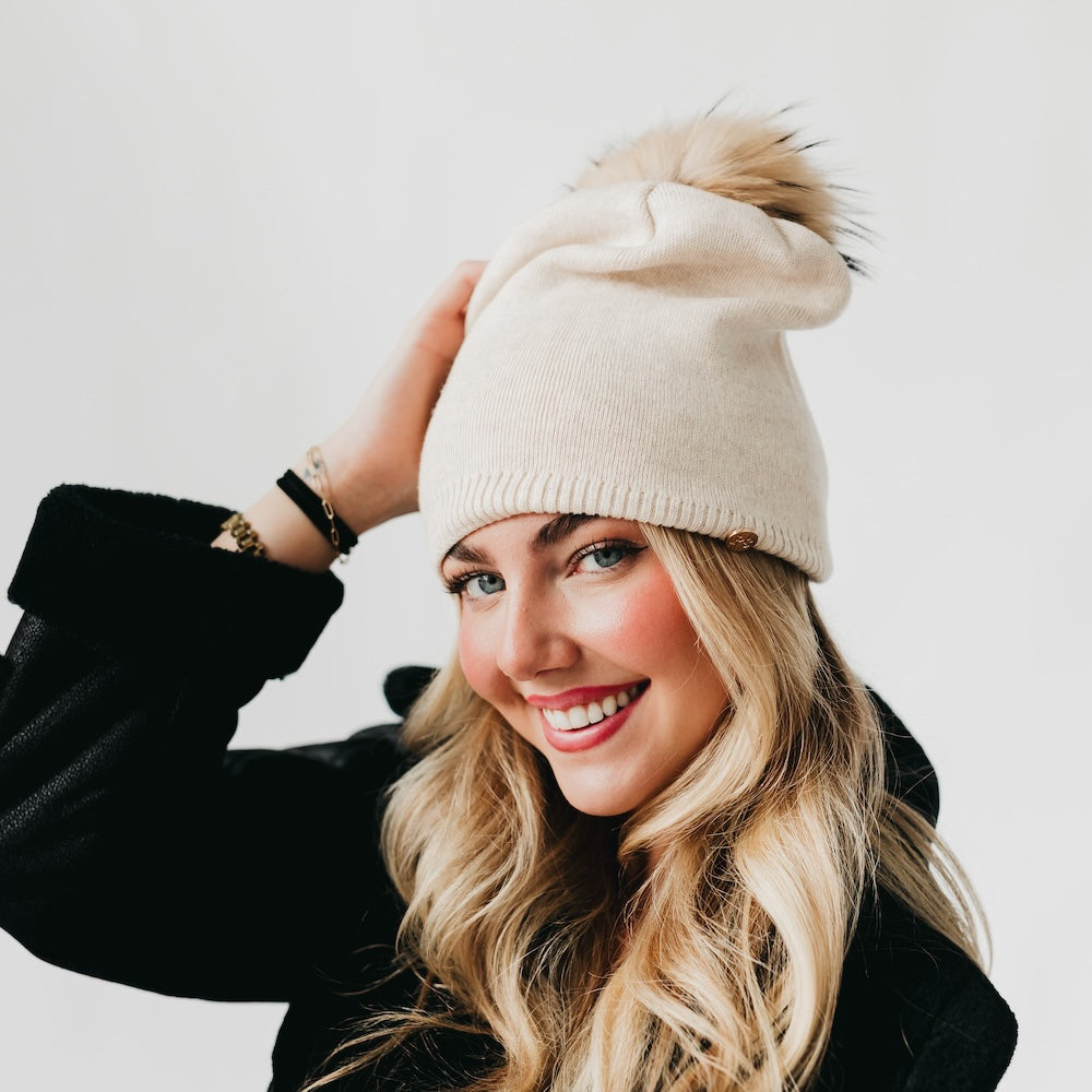Cream knit beanie with ribbed cuff and fur pom