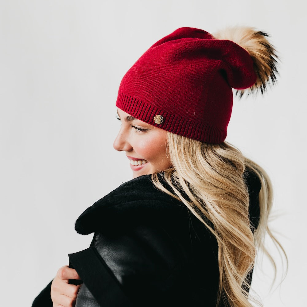 Back view of red slouchy beanie with fur pom