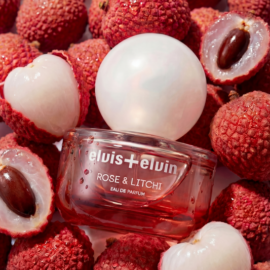 Rose & Litchi eau de parfum bottle with lychee fruit and cut halves