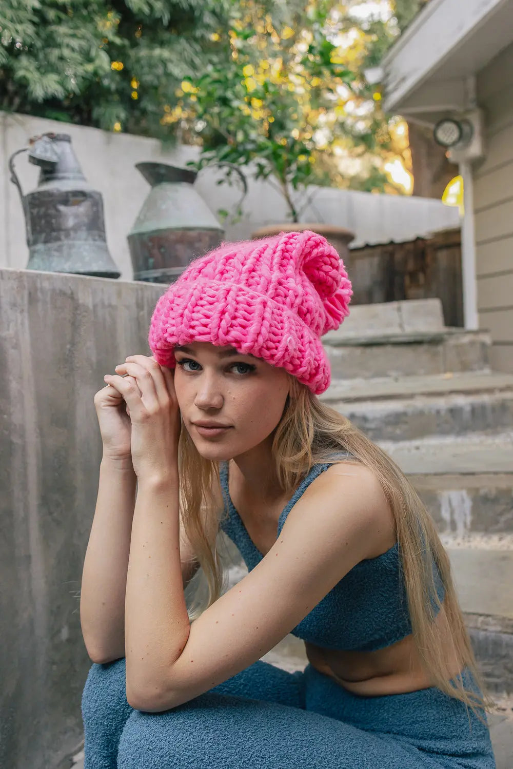 Hot pink chunky cable-knit beanie with folded rib cuff and pom-pom top