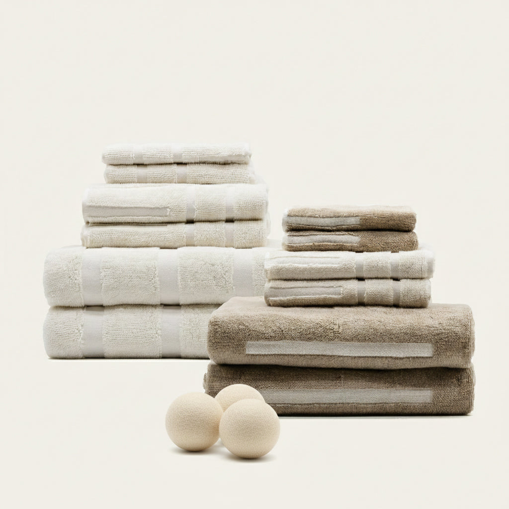 Stacked cotton towels in ecru and tan, neatly folded with plush terry texture
