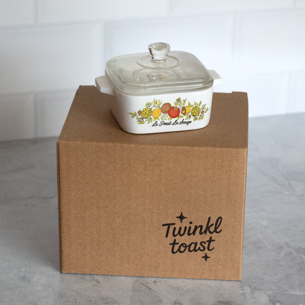 Mini trinket box on gift box; clear lid and fruit-herb illustration on white ceramic body