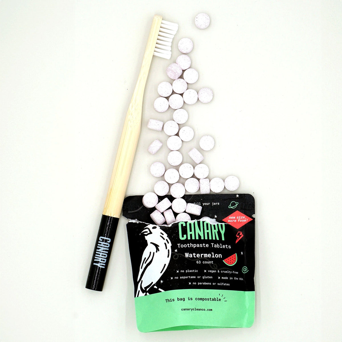 Toothpaste tablet pouch with pale tablets and a bamboo toothbrush; the pouch label reads Watermelon