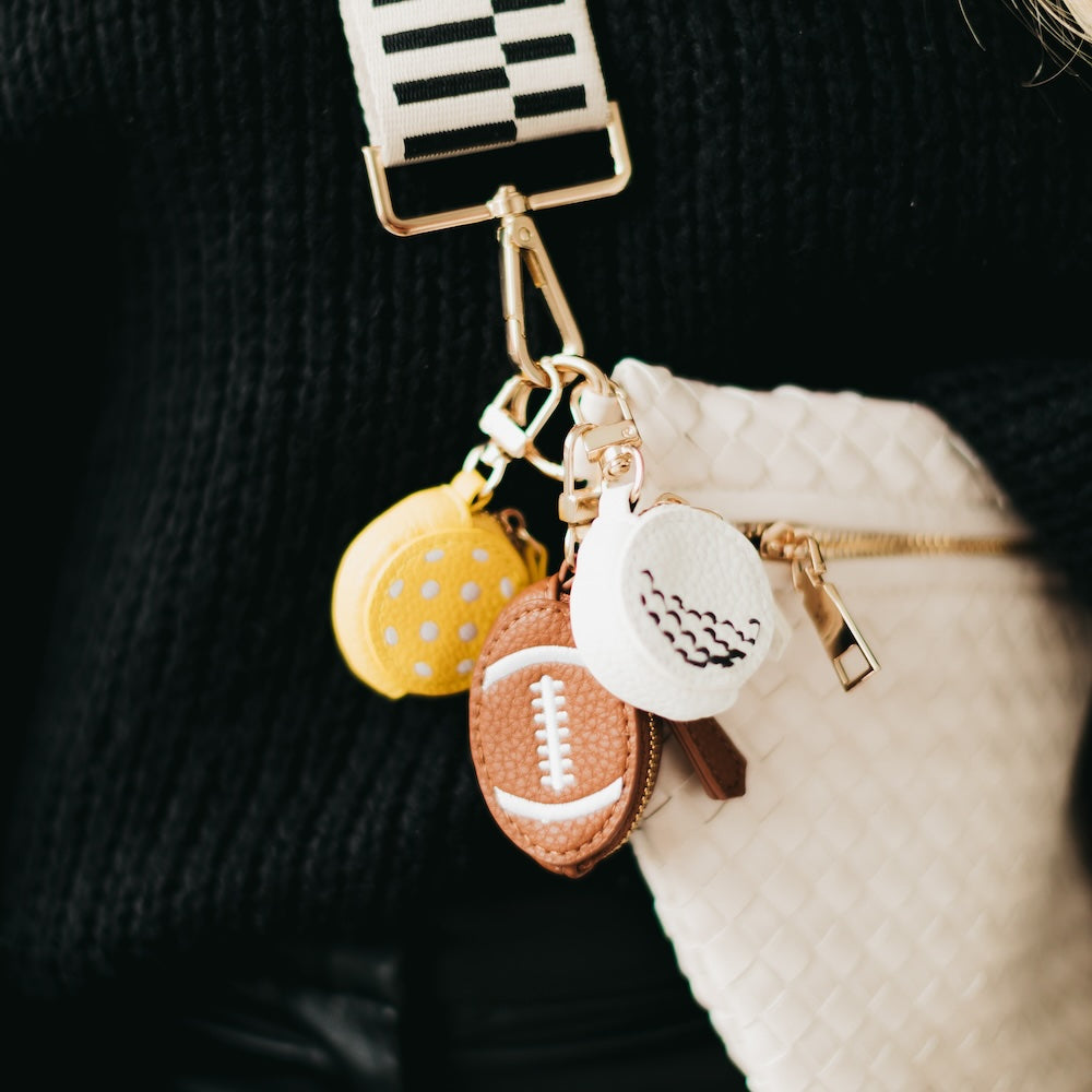 Sports bag charm with three stitched ball charms on a gold chain and lobster clasp