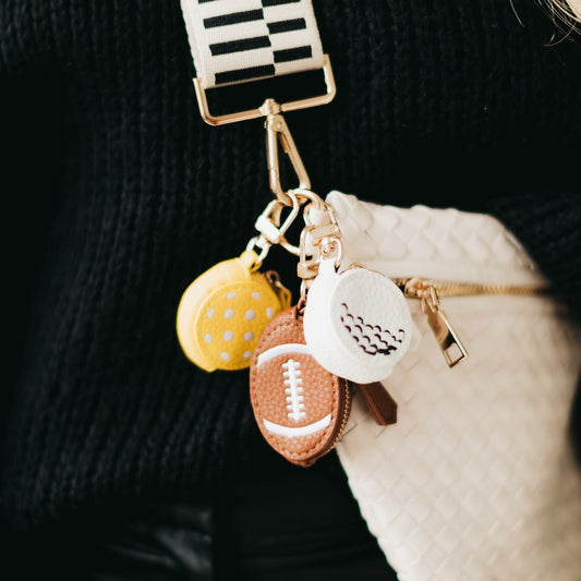 Sports bag charm with three stitched ball charms on a gold chain and lobster clasp
