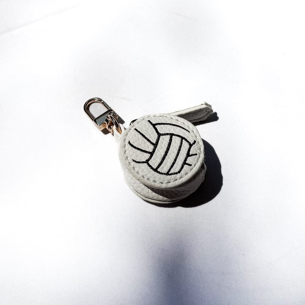 Gray sports bag charm ball with black line drawing on a gold keyring clip
