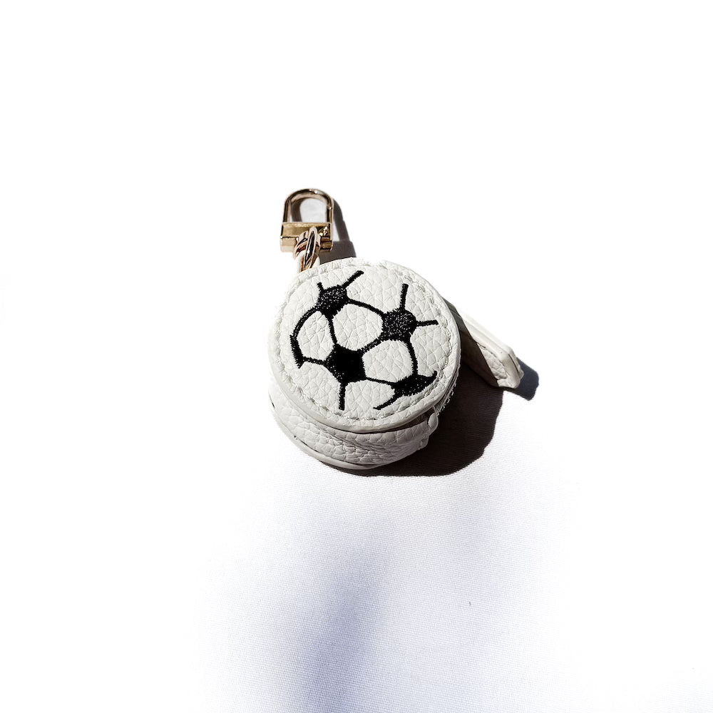 White sports bag charm ball with black hexagon soccer stitching on a gold keyring