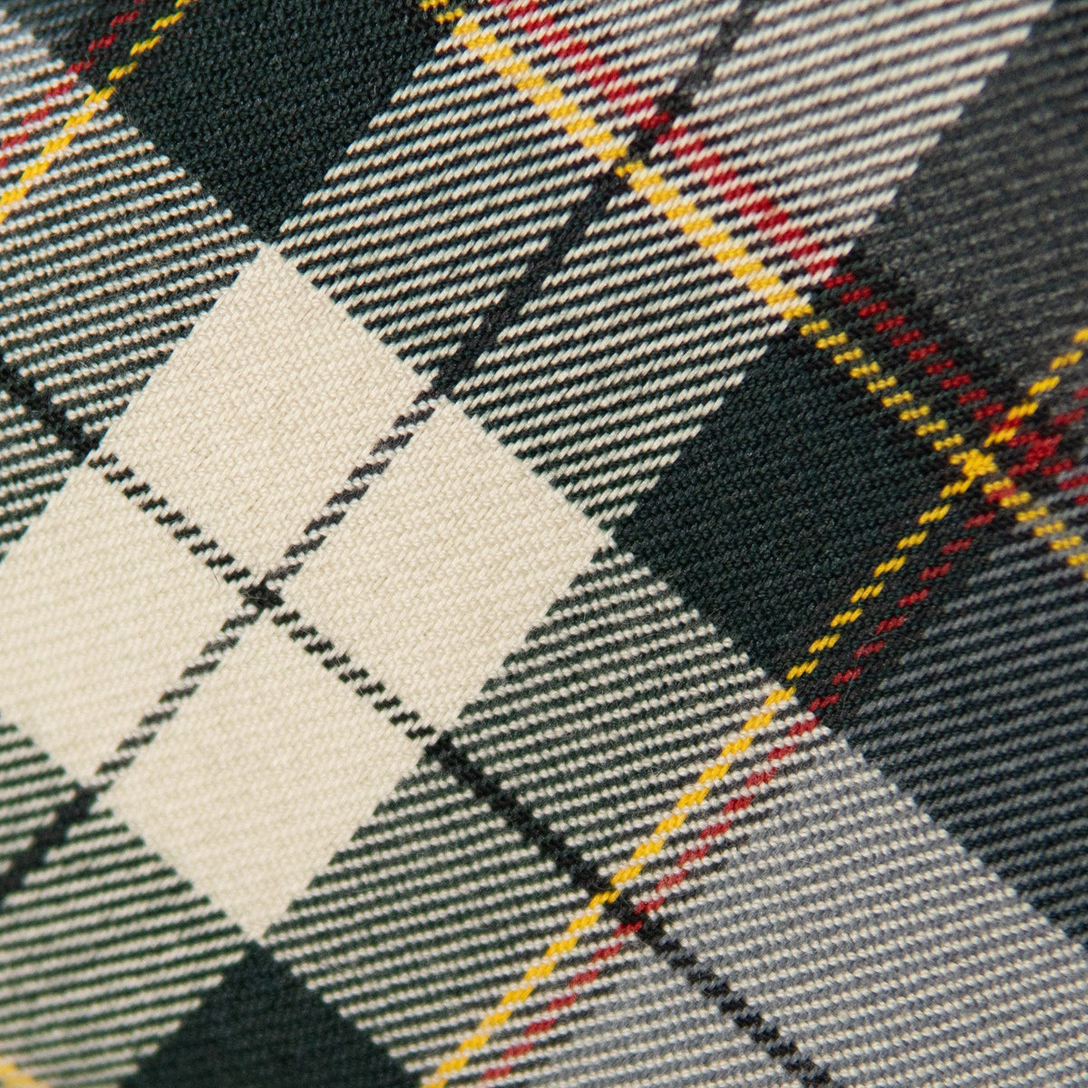 Plaid bow tie fabric close-up: green, cream, red, and yellow lines