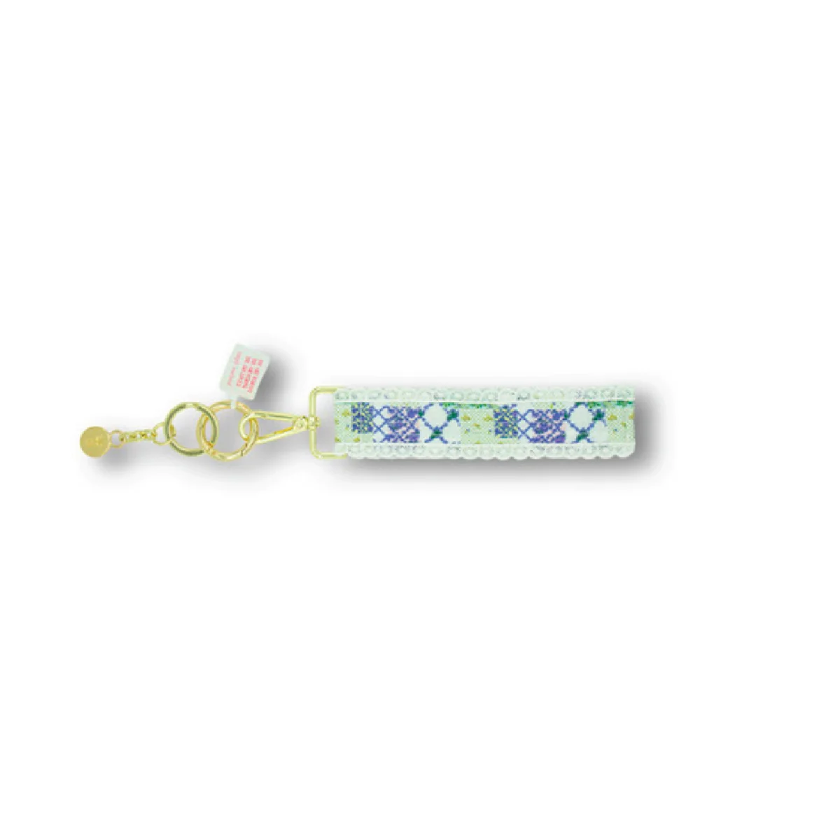 Lace keyfob with blue patterned patch, metal rings, and small bead charm