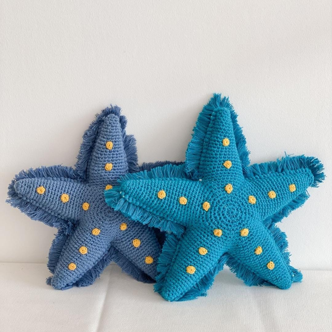 Two starfish-shaped plush toys in blue and teal with yellow spots and fringed edges