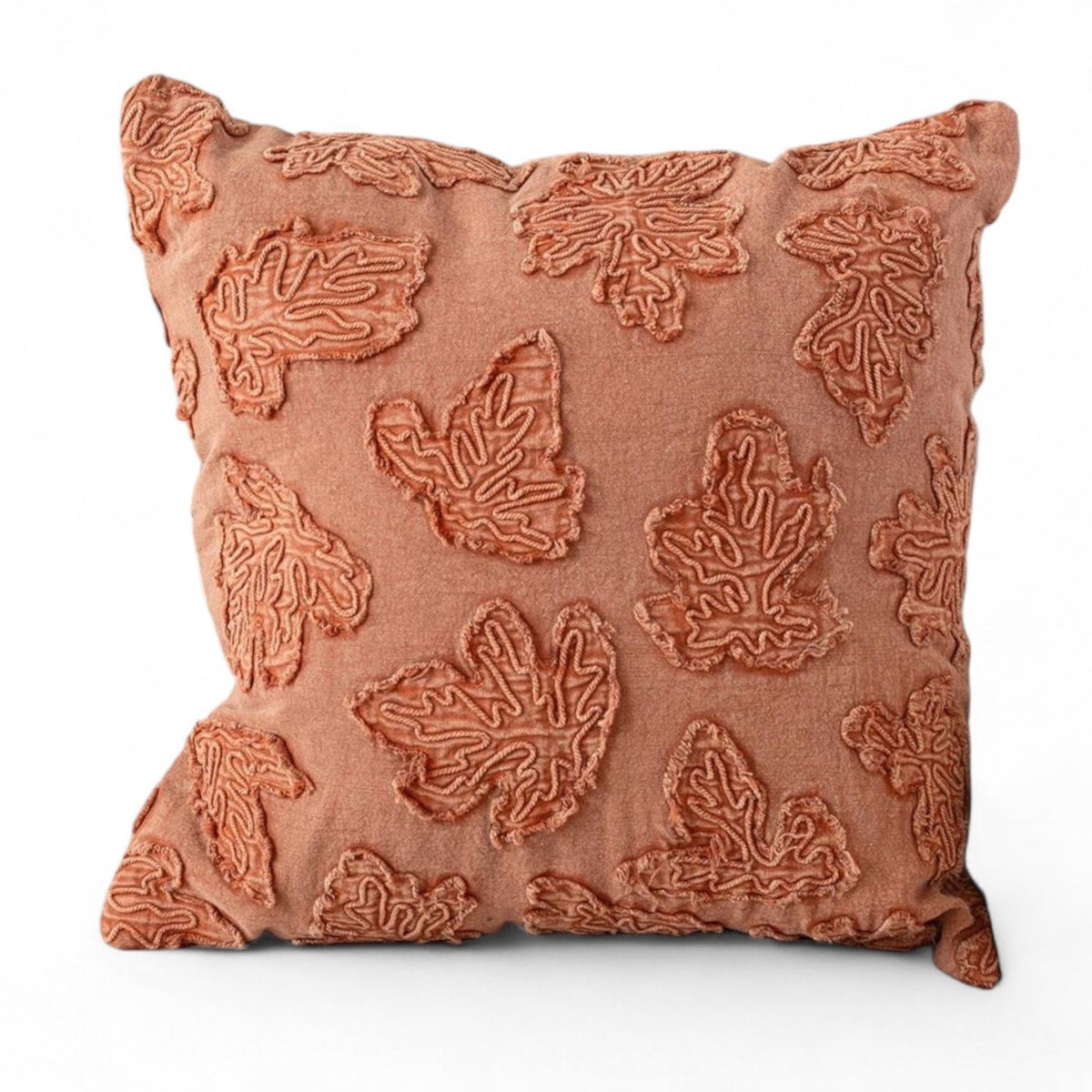 Square throw pillow in rust-orange with raised embroidered leaf pattern