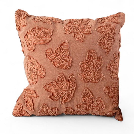Square throw pillow in rust-orange with raised embroidered leaf pattern