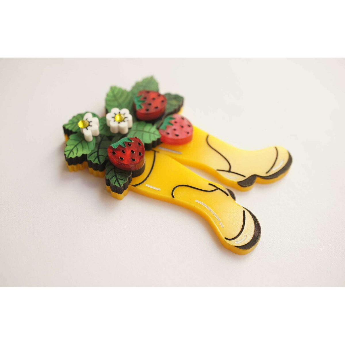 Yellow boot brooch depicting two boots, topped with strawberry clusters and green leaves
