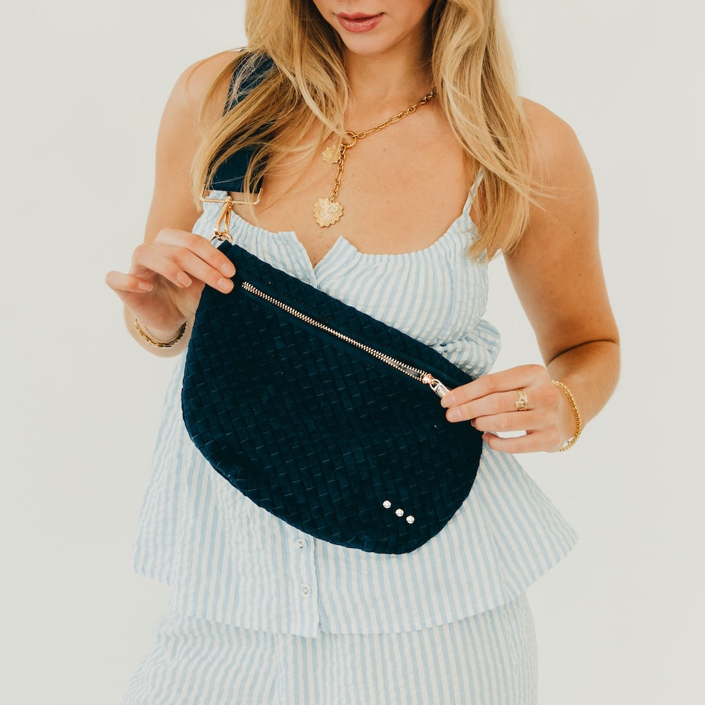 Dark teal woven suede bum bag with top zipper, gold-tone hardware, and small studs