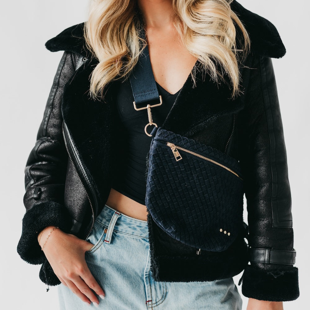 Black woven suede bum bag with top zipper and gold-tone D-ring strap hardware