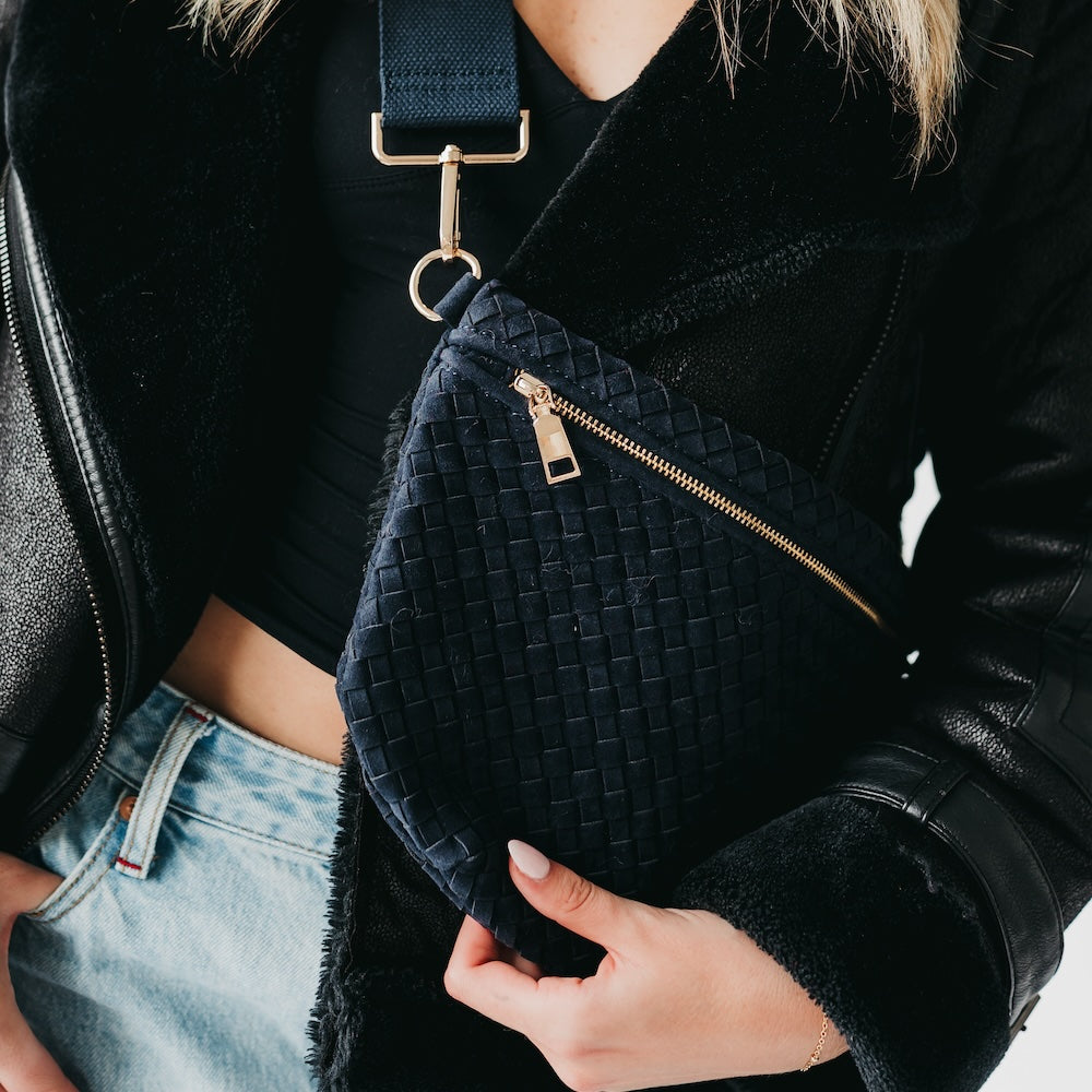 Black woven suede bum bag close-up with zipper and gold-tone strap hardware