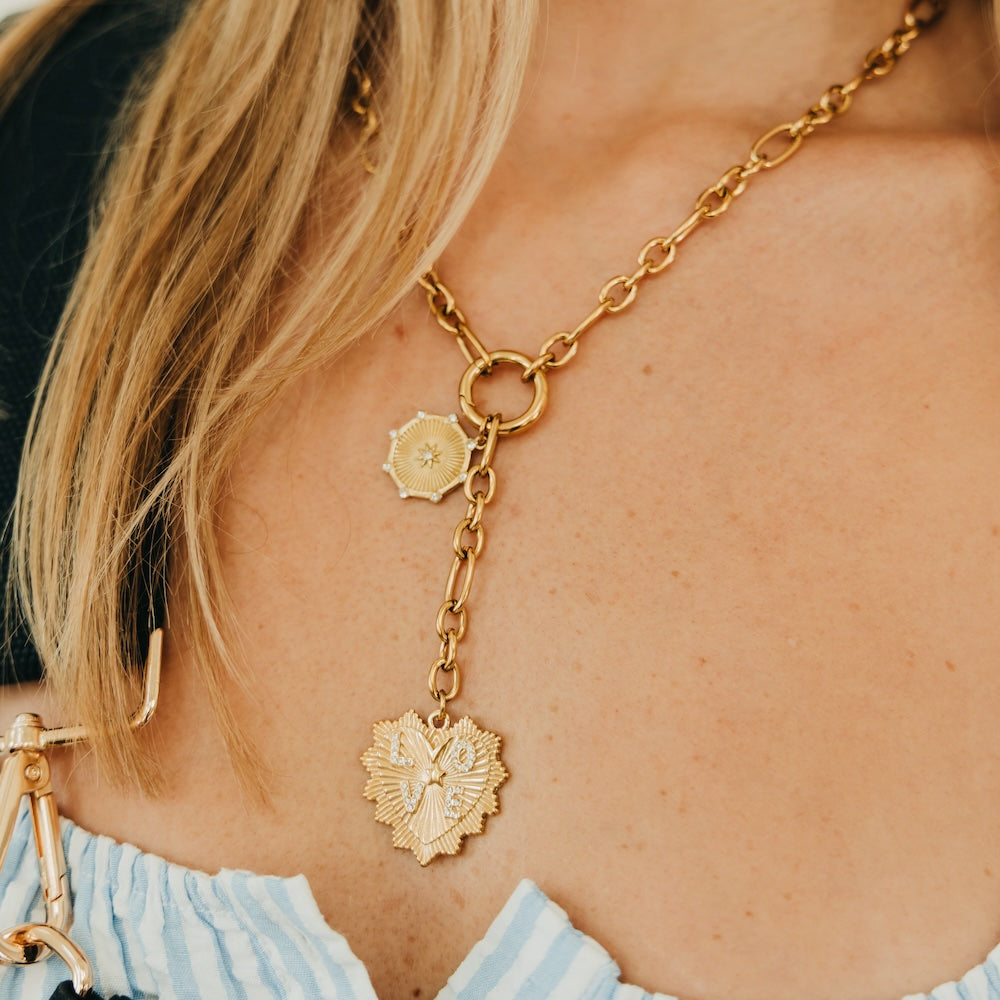 Gold-tone chain necklace with hanging sunburst heart pendant and small hoop links
