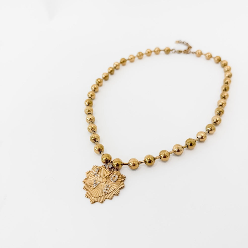 Gold-tone ball chain necklace with round beads and sunburst heart pendant