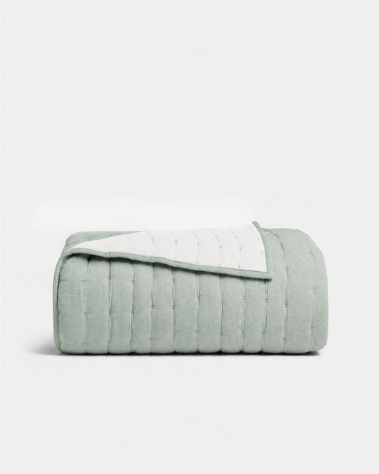 Blue cotton quilt with stitched channels and folded edge, quilted bedding cover