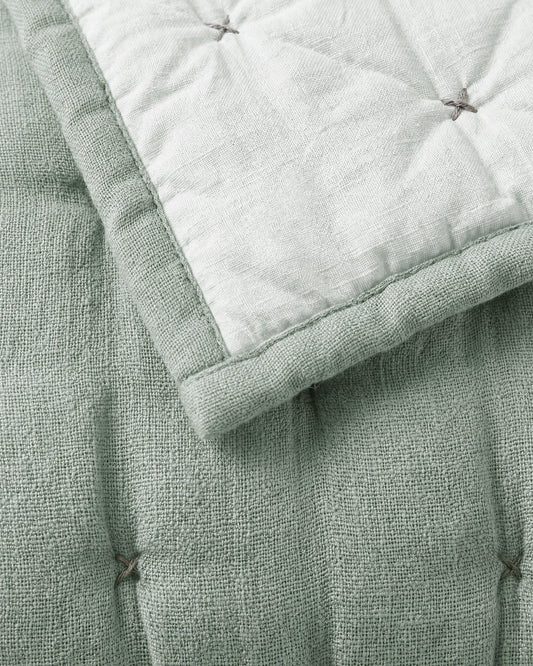 Misty blue quilt corner detail with contrast stitching and pin-tuck knot details