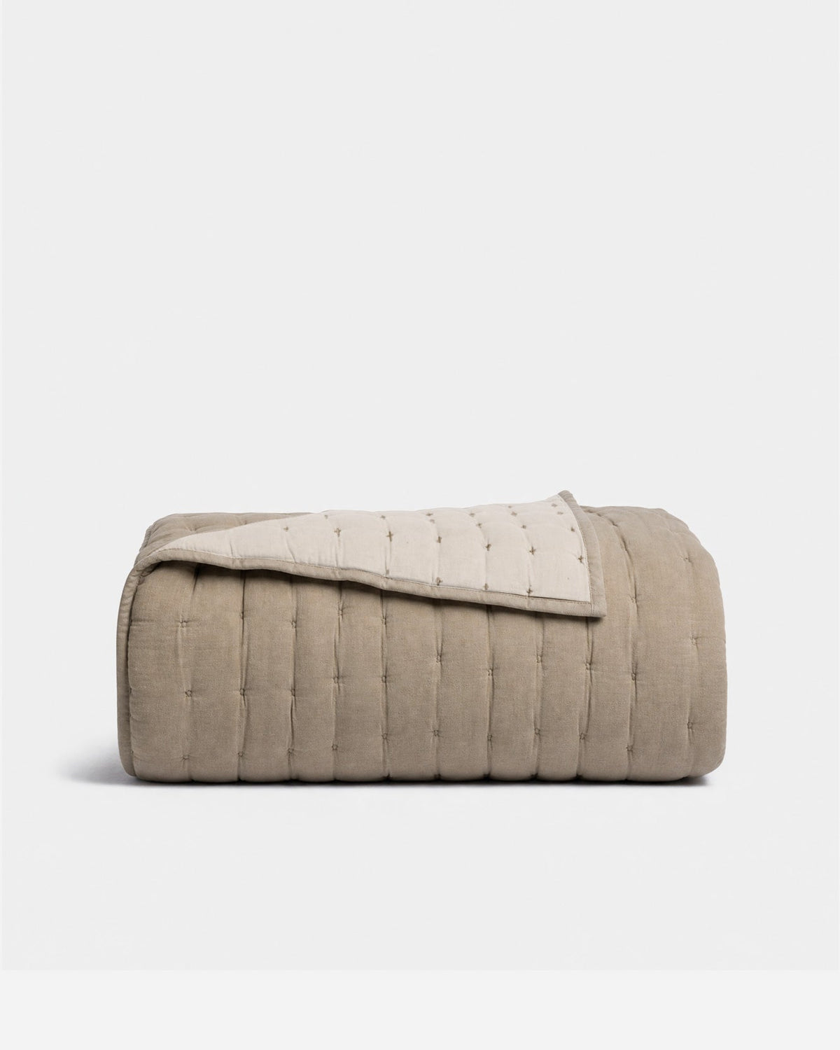 Taupe cotton quilt with stitched channels and folded edge, quilted bedding cover