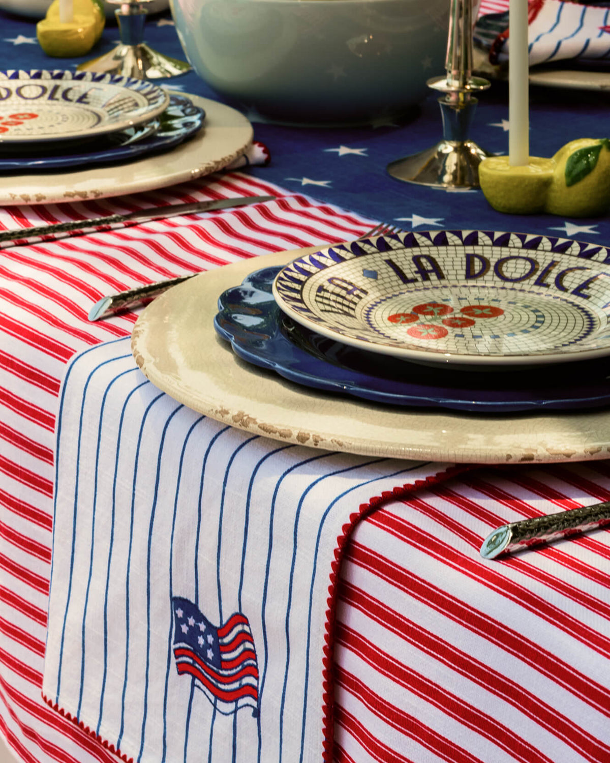 Red and off-white striped tablecloth with blue star and flag patchwork corner.