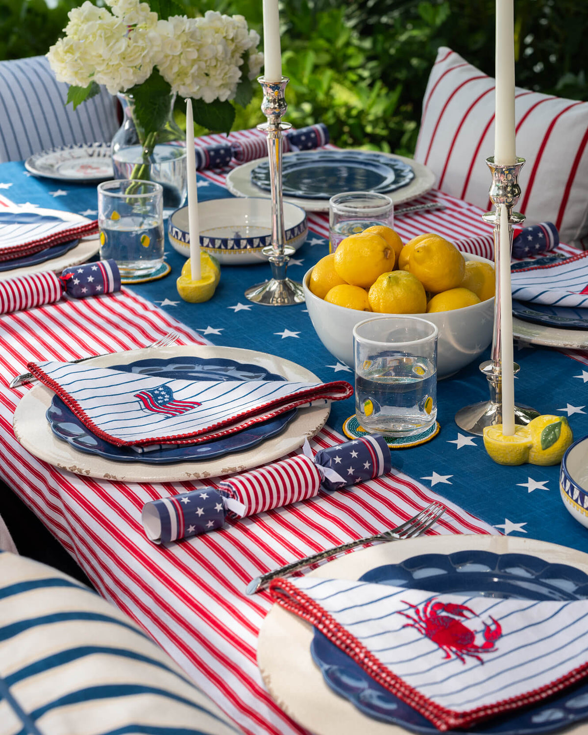 Red and off-white striped tablecloth with blue star sections and folded napkins.