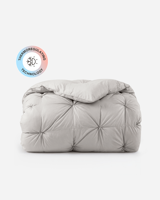 White quilted comforter with circular tufted stitching, folded