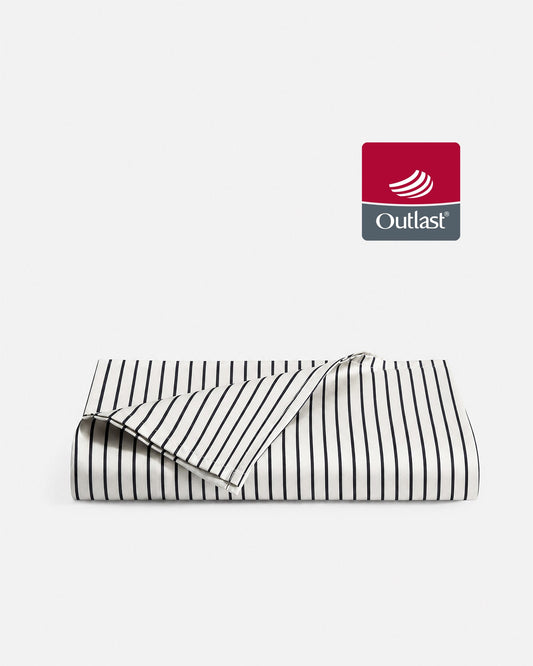 Striped white and dark blue cooling top sheet, folded with stitched edge and piping