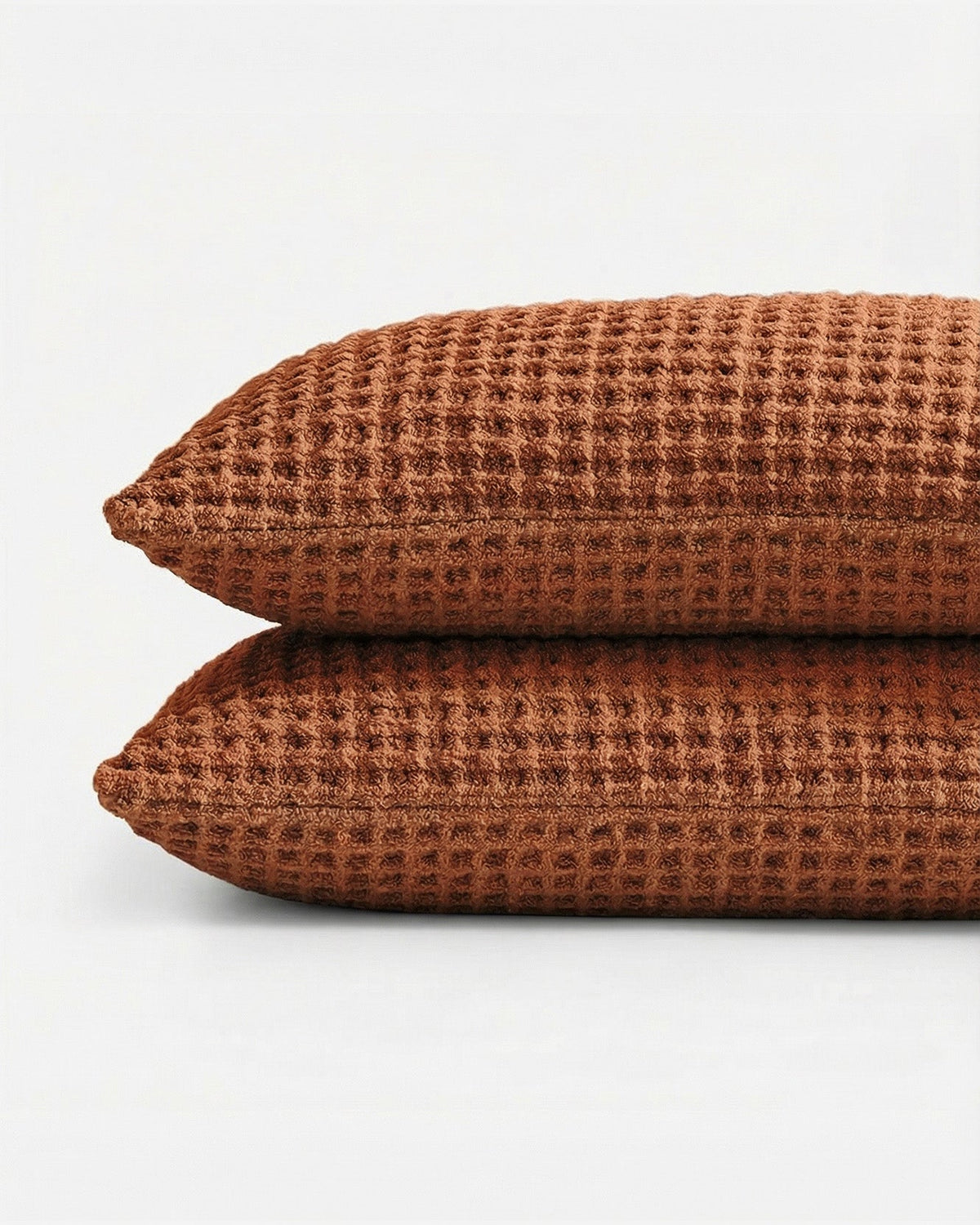 Stacked cinnamon waffle pillow shams with grid texture and matching seams