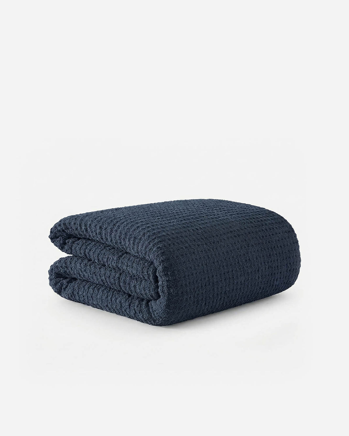 Midnight blue waffle comforter, folded with visible waffle texture