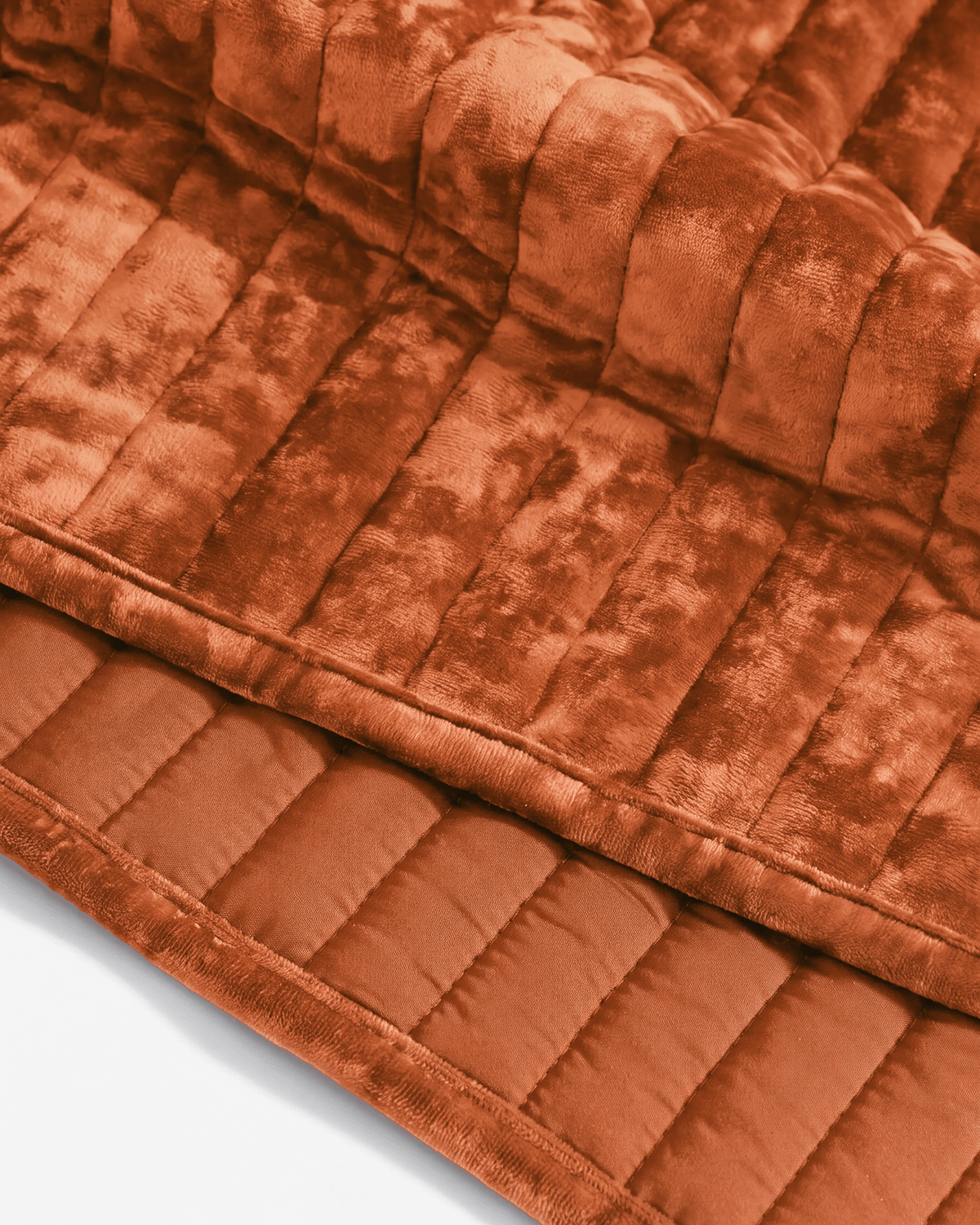 Rust velvet channel quilt close-up, raised stripes with stitched border and smooth pile