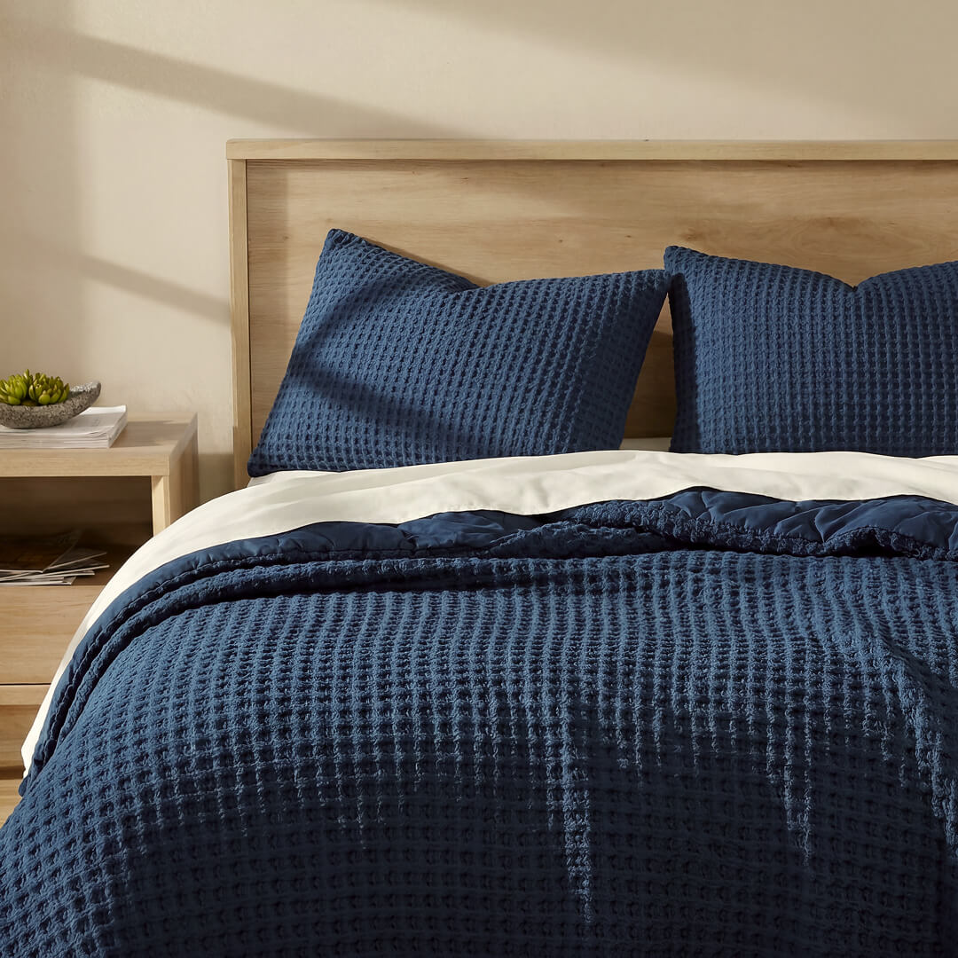 Midnight blue waffle comforter on bed with two matching shams