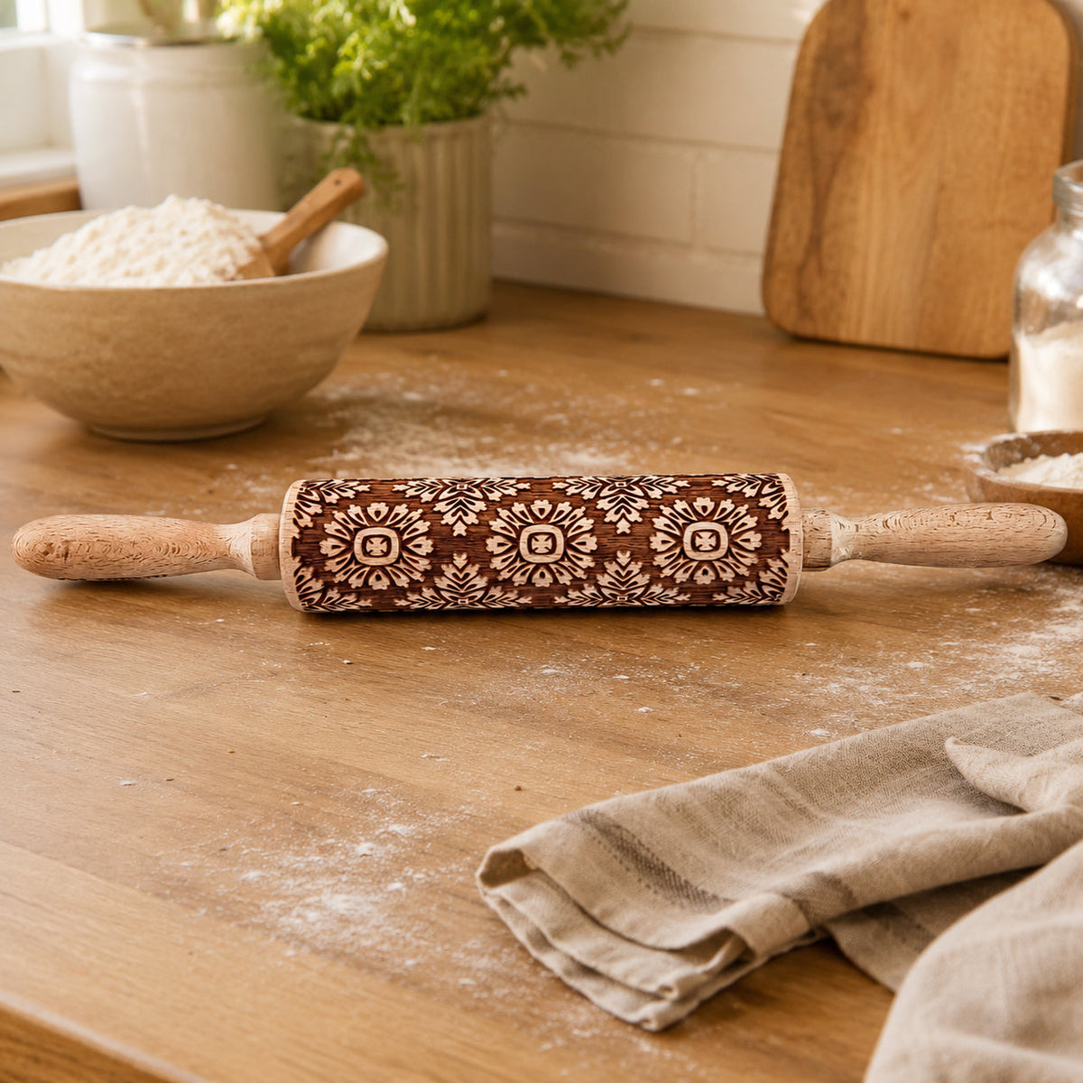 Set of three embossed wood rolling pins with dark boho floral patterns on a table