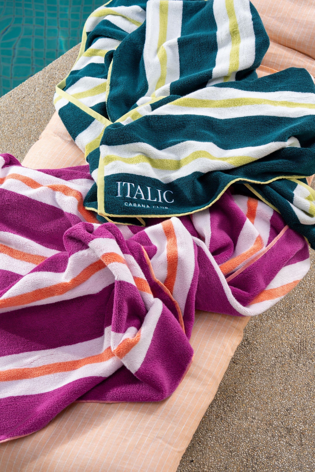 Cotton beach towel in purple and white stripes with coral and orange accents