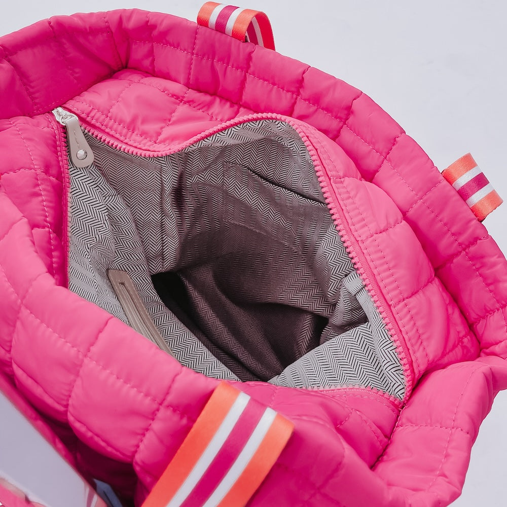 Pink quilted tote roller bag interior view with textured gray lining