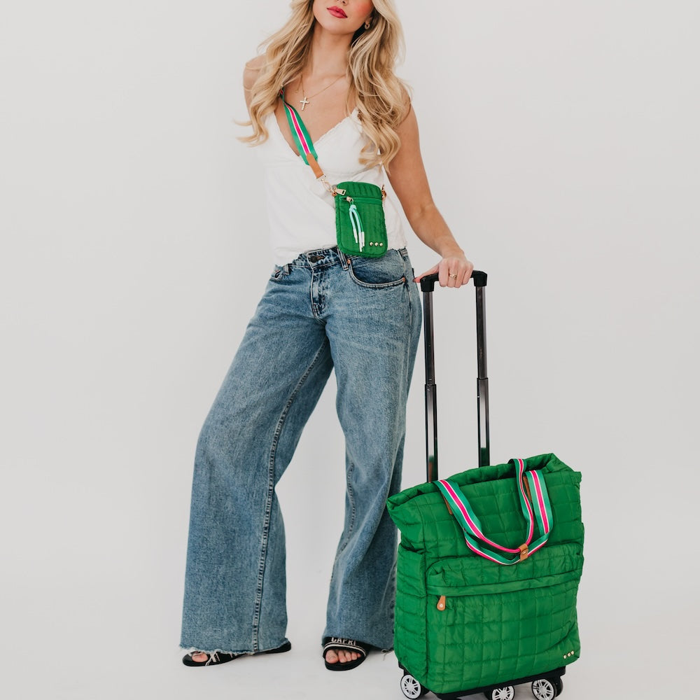 Quilted emerald tote roller bag with striped handles, carried on rolling cart