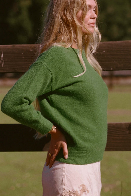 Hunter green knit sweater, crew neck, long sleeves with side view drape