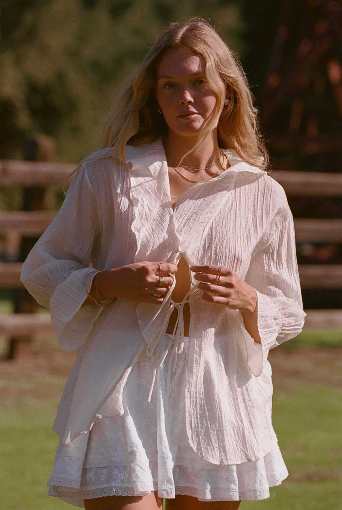 Ivory tiered ruffle top with long sleeves and lace-up neckline ties