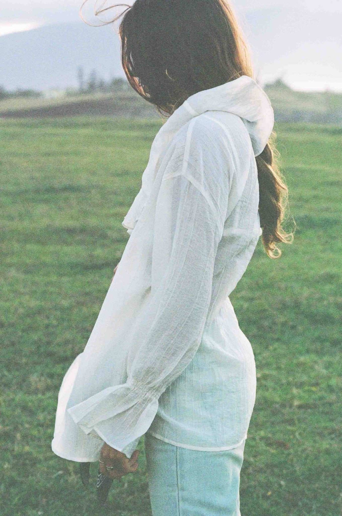 Ivory lightweight ruffle top with long sleeves and open back design