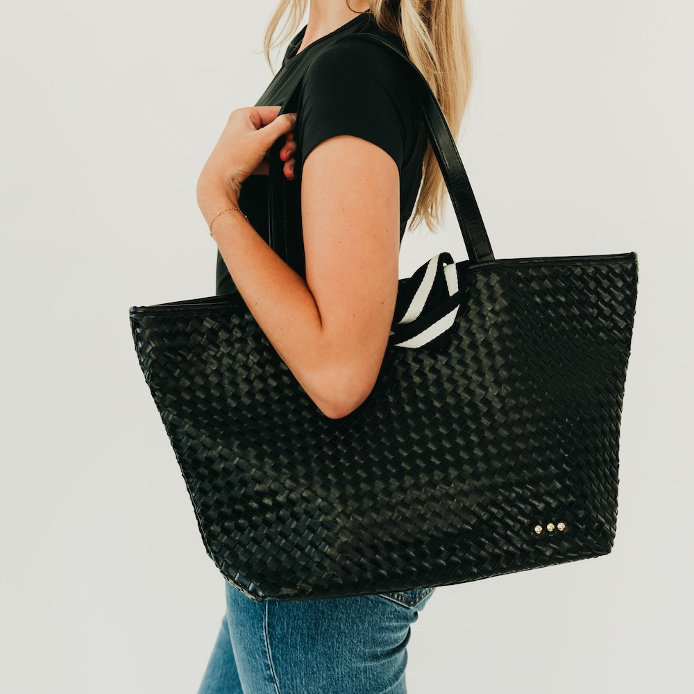 Woven black organizer tote bag with sturdy black handles and small gold snap detail