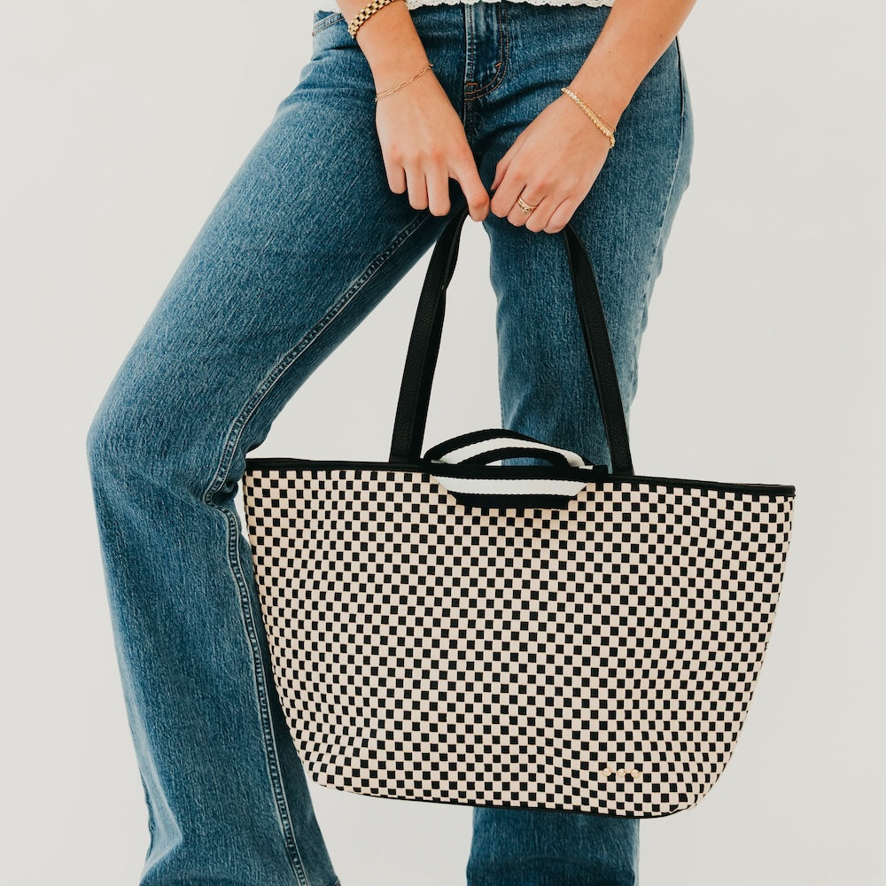 Woven checkered tote bag with black and cream pattern and black carry handles