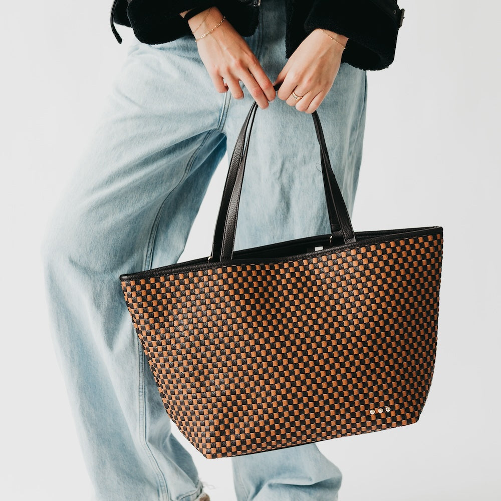 Woven checkered tote bag in brown and black with black top handles