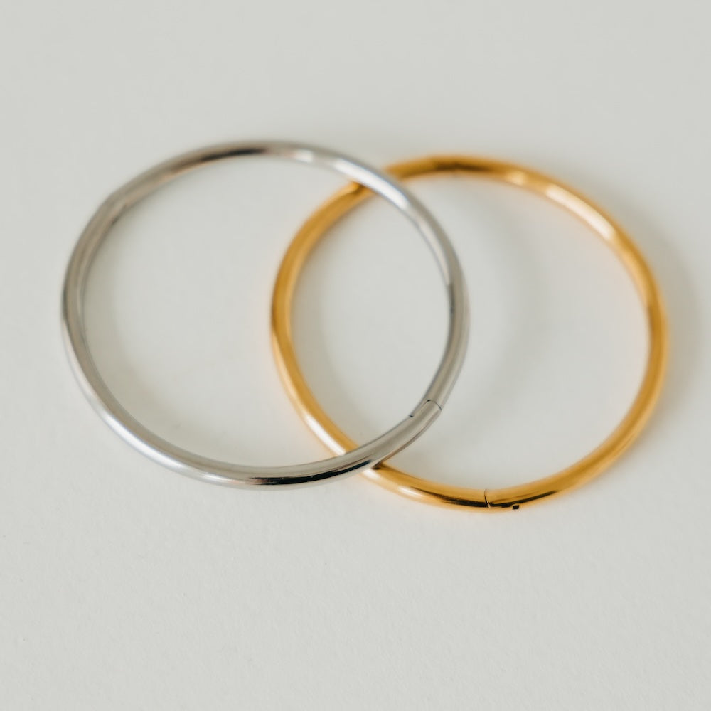 Gold and silver bangle bracelets, stacked round cuffs with glossy shine