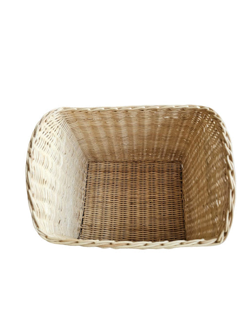 Top view of the deep woven interior of a beige rattan toy basket
