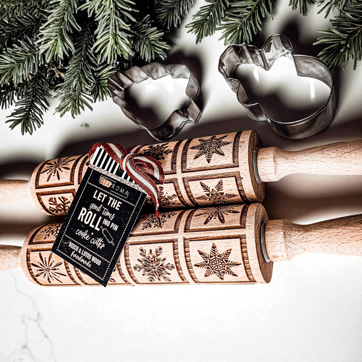 Two wooden Christmas rolling pins with geometric star patterns and attached product tags.